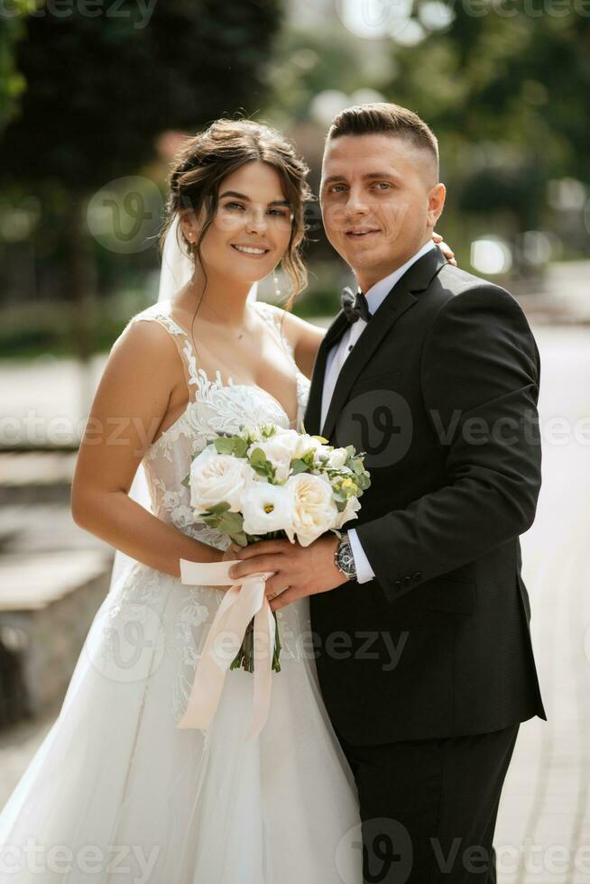 le marié en costume marron et la mariée en robe blanche photo