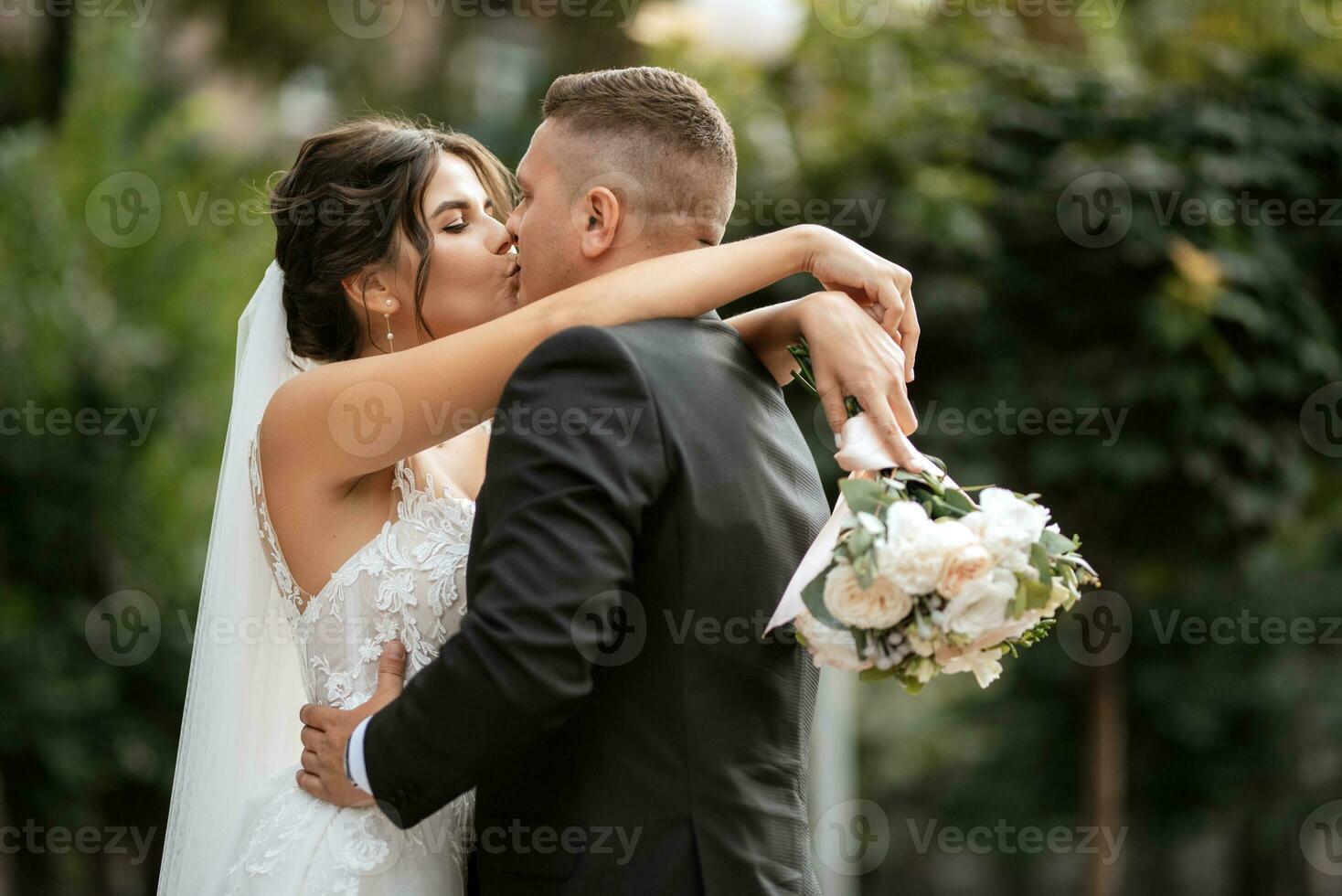 le marié en costume marron et la mariée en robe blanche photo