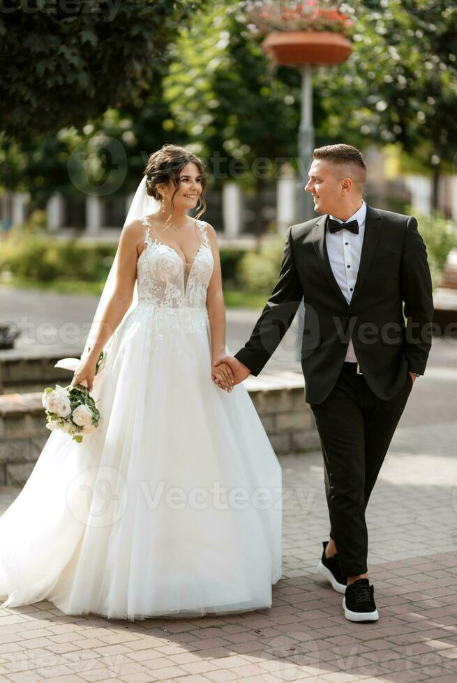 le marié en costume marron et la mariée en robe blanche photo