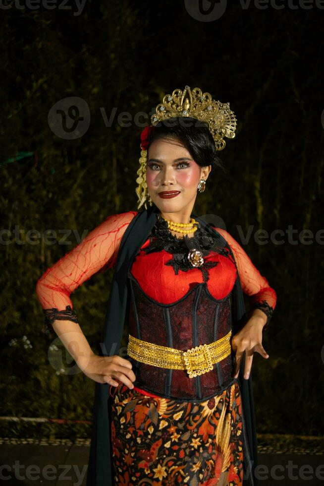 une vietnamien Danseur portant une rouge costume et or bijoux sur étape à nuit photo