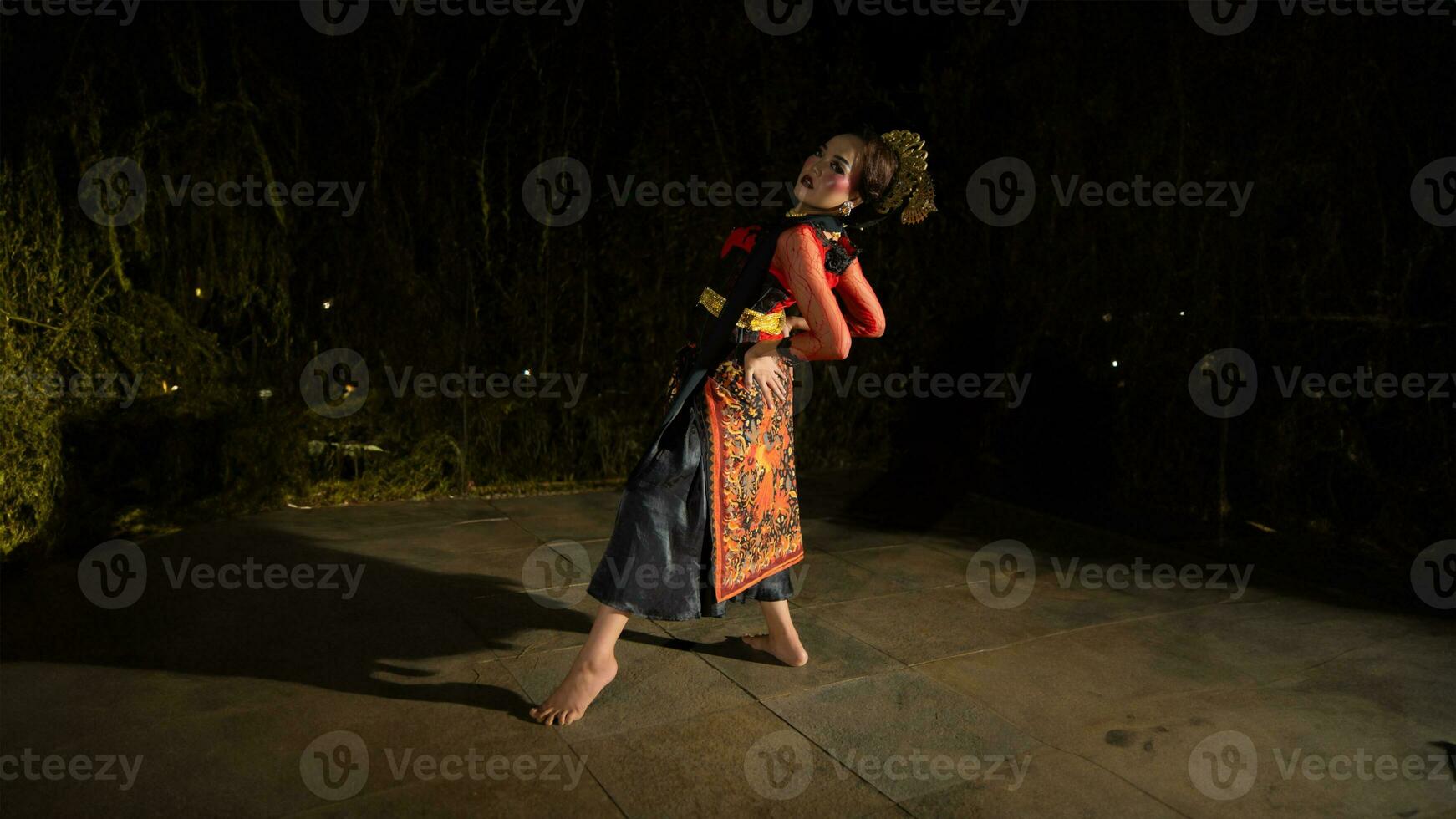 un indonésien Danseur portant bijoux cette brille en dessous de le projecteur de le étape lumières ajoute à le éclat de le performance photo