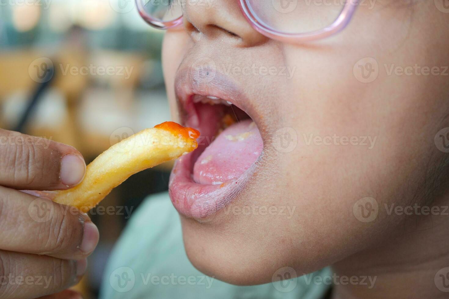 enfant en mangeant français frites proche en haut photo