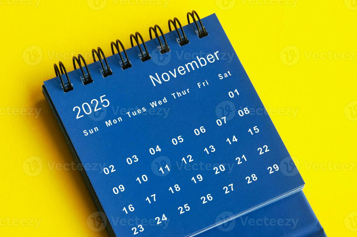 2025 bleu bureau calendrier sur Jaune couverture Contexte. photo