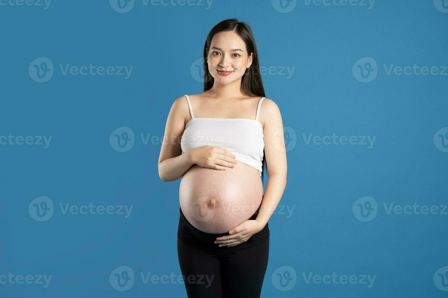 portrait de Enceinte asiatique femme, isolé sur bleu Contexte photo