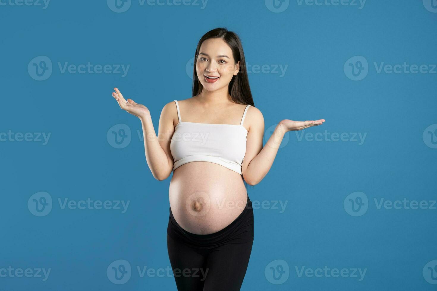 portrait de Enceinte asiatique femme, isolé sur bleu Contexte photo