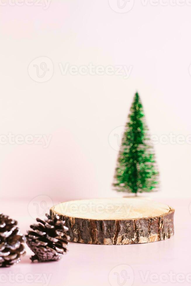 bois Couper podium, décoratif Noël arbre et pin cônes sur une rose Contexte verticale vue photo