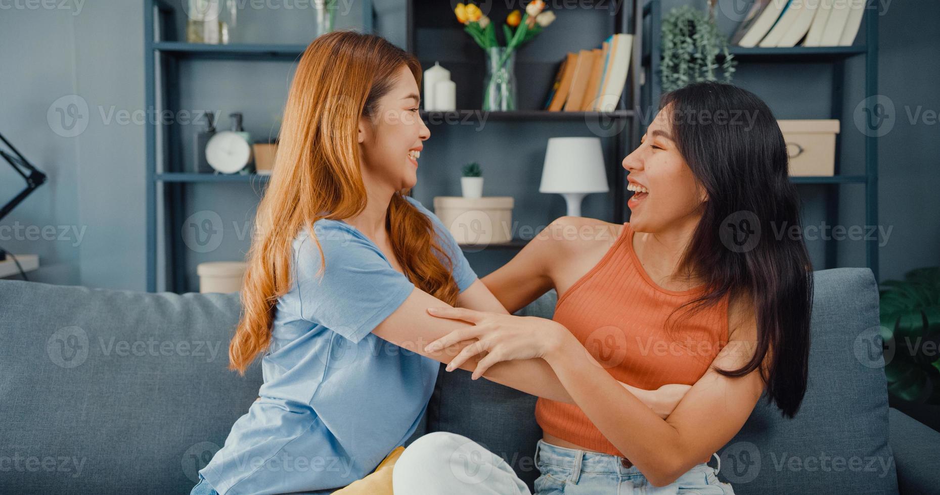 une adolescente asiatique heureuse rend visite à ses amis proches en souriant à la maison. Les meilleurs copains ravis et excités s'embrassent, se saluent avec succès, un véritable concept d'amitié forte. photo