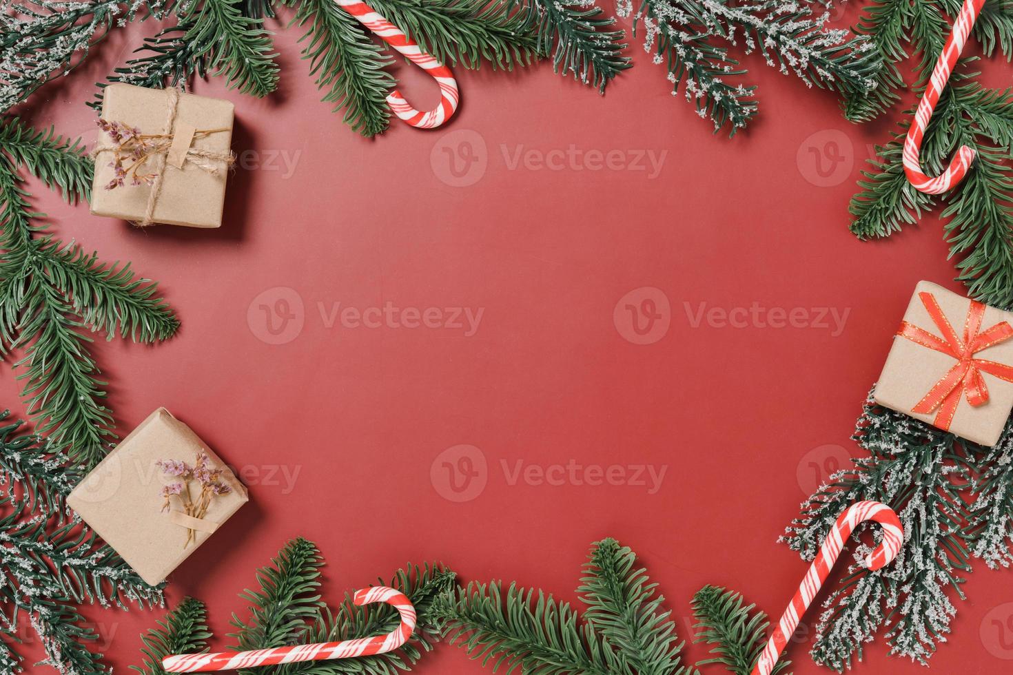 mise à plat créative minimale de la composition traditionnelle de noël et de la saison des vacances du nouvel an. vue de dessus des décorations de noël d'hiver sur fond rouge avec un espace vide pour le texte. copier la photographie de l'espace. photo