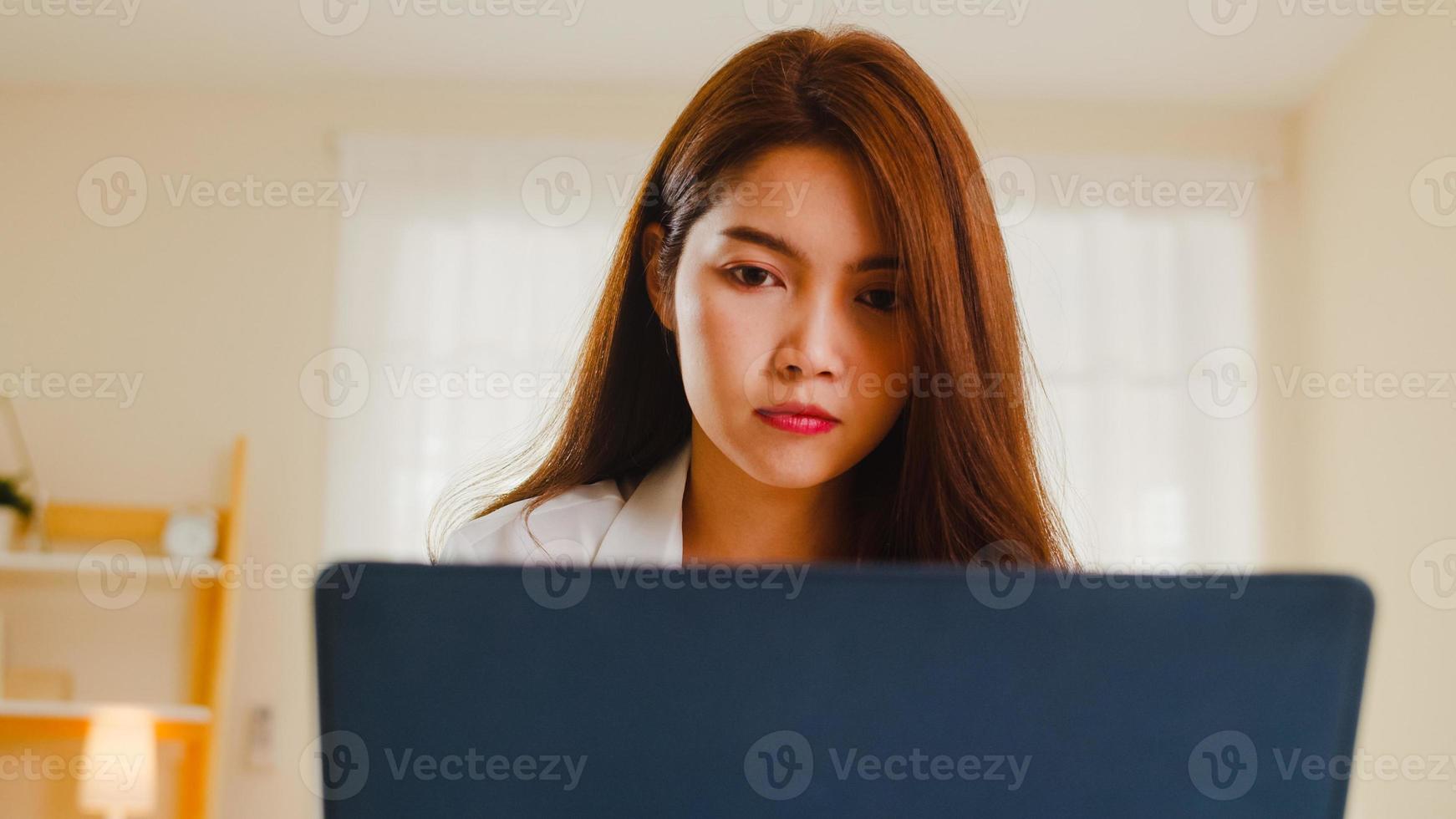 portrait de femmes asiatiques indépendantes tenues décontractées à l'aide d'un ordinateur portable travaillant dans le salon à la maison. travail à domicile, travail à distance, auto-isolement, distanciation sociale, quarantaine pour la prévention des coronavirus. photo