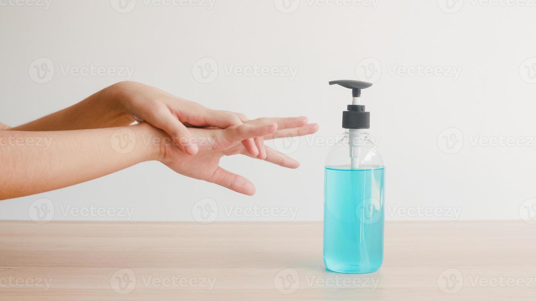 femme asiatique utilisant un désinfectant pour les mains au gel d'alcool se laver les mains pour protéger le coronavirus. une femme pousse une bouteille d'alcool pour nettoyer la main pour l'hygiène lorsque la distanciation sociale reste à la maison et le temps d'auto-quarantaine. photo