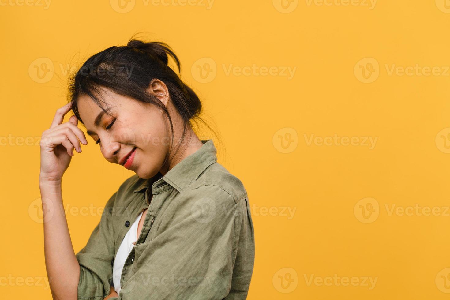 portrait d'une jeune femme asiatique avec une expression positive, un large sourire, vêtue de vêtements décontractés sur fond jaune. heureuse adorable femme heureuse se réjouit du succès. concept d'expression faciale. photo