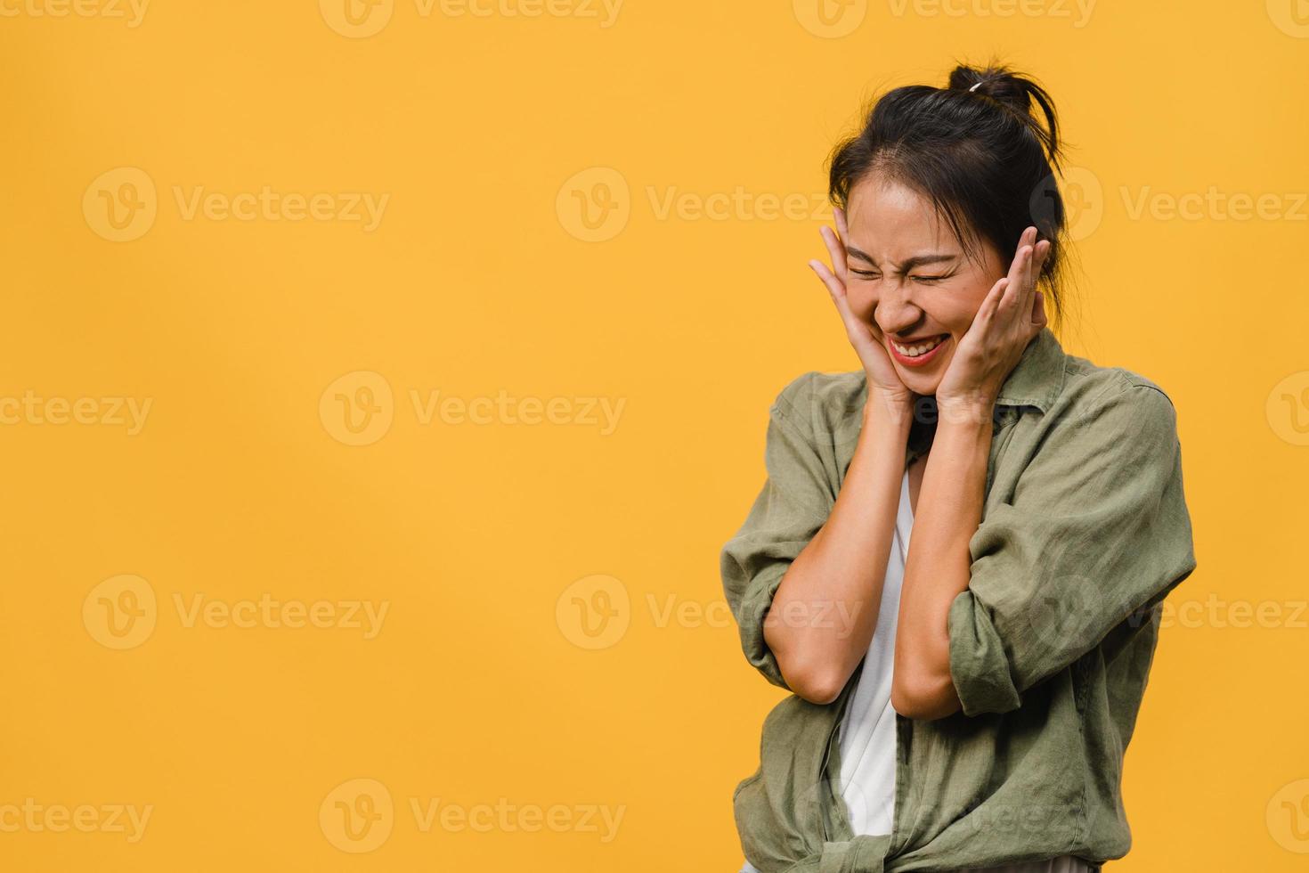 portrait d'une jeune femme asiatique avec une expression positive, un large sourire, vêtue de vêtements décontractés sur fond jaune. heureuse adorable femme heureuse se réjouit du succès. concept d'expression faciale. photo