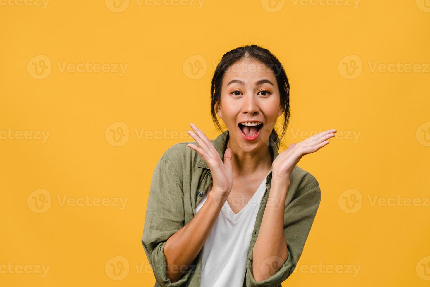 la jeune femme asiatique ressent le bonheur avec une expression positive, une joyeuse surprise funky, vêtue d'un tissu décontracté et regardant la caméra isolée sur fond jaune. heureuse adorable femme heureuse se réjouit du succès. photo