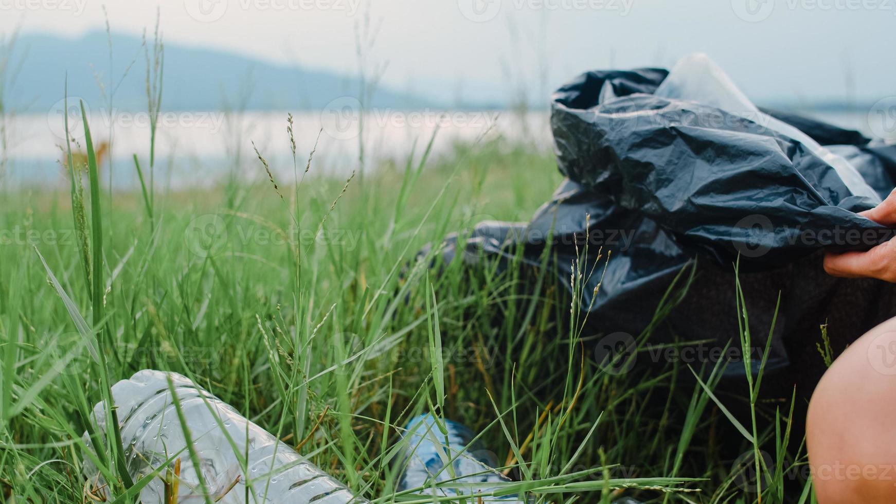 joyeux jeunes activistes asiatiques ramassant des déchets plastiques dans la forêt. Des femmes bénévoles coréennes aident à garder la nature propre et à ramasser les ordures. concept sur les problèmes de pollution de la conservation de l'environnement. photo