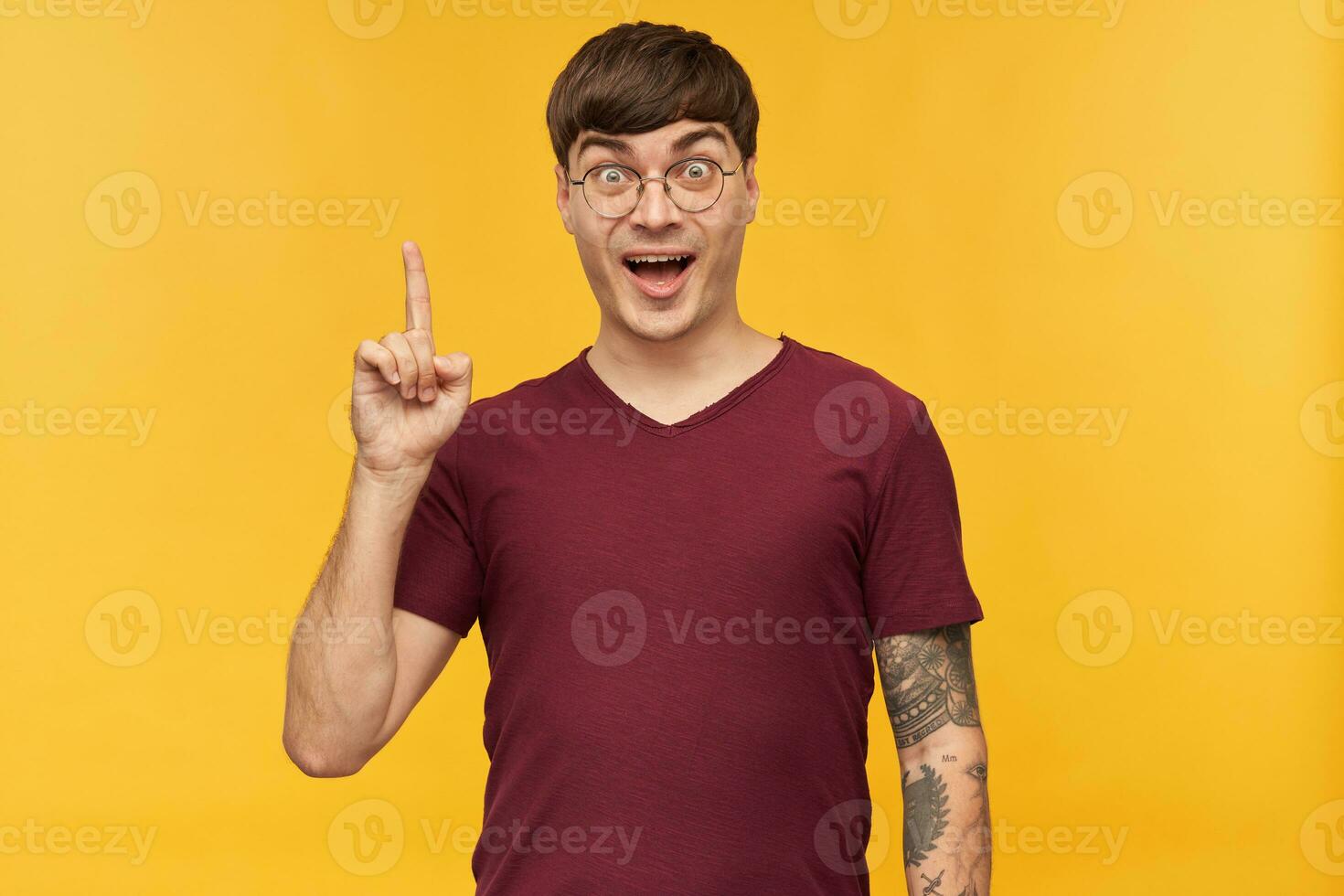 je avoir un idée. intérieur coup de Jeune étudiant homme, sourit largement et avoir étonné faciale expression, points avec une doigt vers le haut. isolé plus de Jaune Contexte. photo