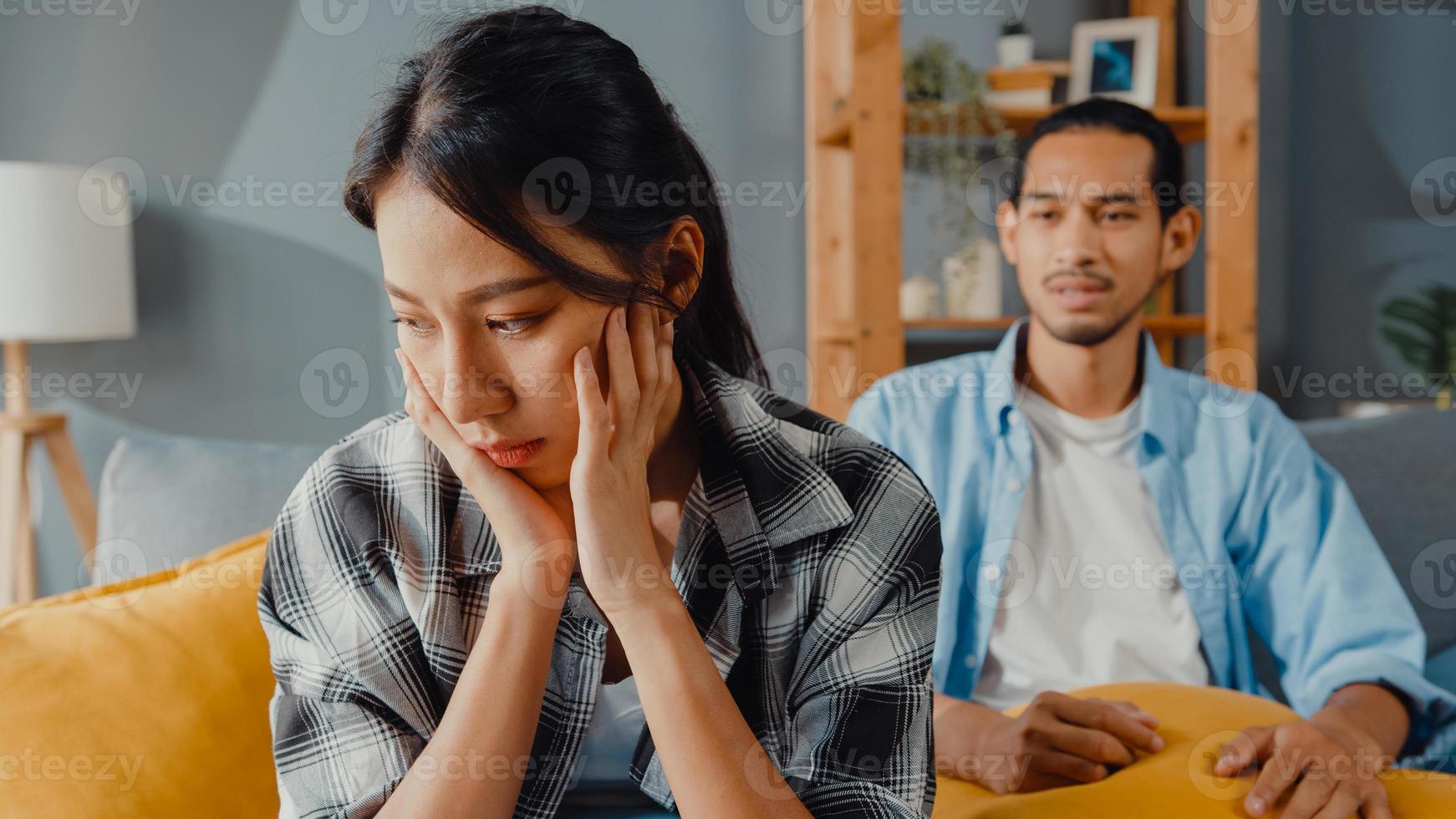 une femme de couple asiatique bouleversée s'asseoir sur un canapé écouter un mari furieux crier se sentir malheureux lui parler négativement. couple a une dispute ou un désaccord à la maison, problème de couple, relation toxique familiale mariée. photo