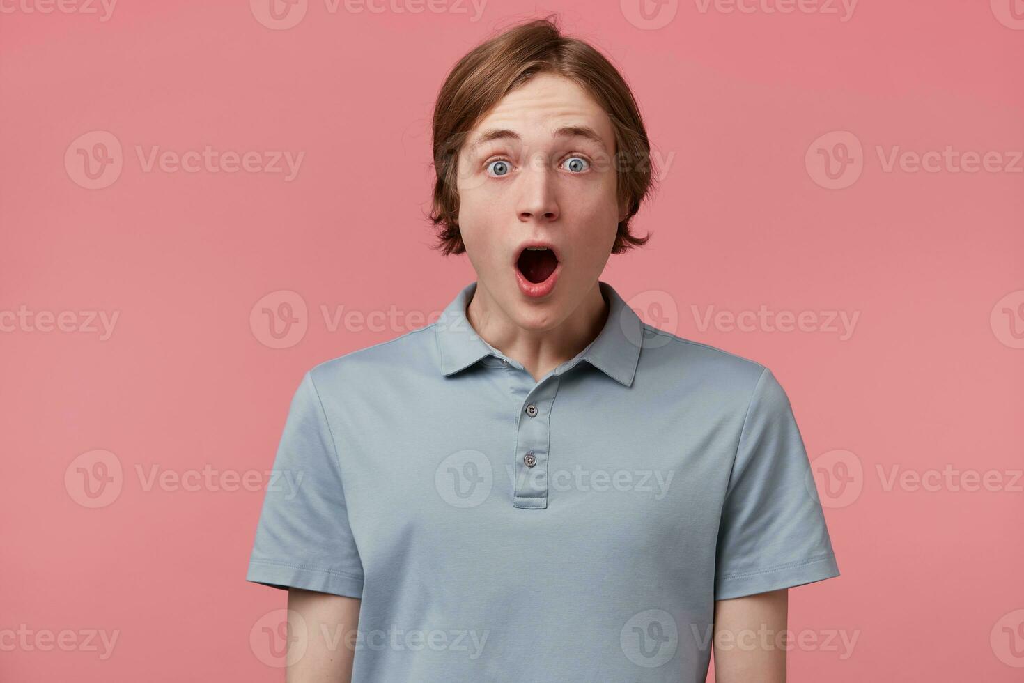 portrait de Jeune homme avec choqué, étonné expression et chuté mâchoire habillé dans polo T-shirt isolé sur rose Contexte photo