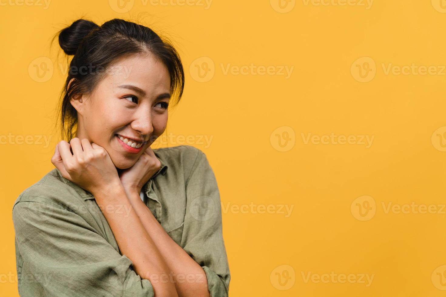 portrait d'une jeune femme asiatique avec une expression positive, un large sourire, vêtue de vêtements décontractés sur fond jaune. heureuse adorable femme heureuse se réjouit du succès. concept d'expression faciale. photo