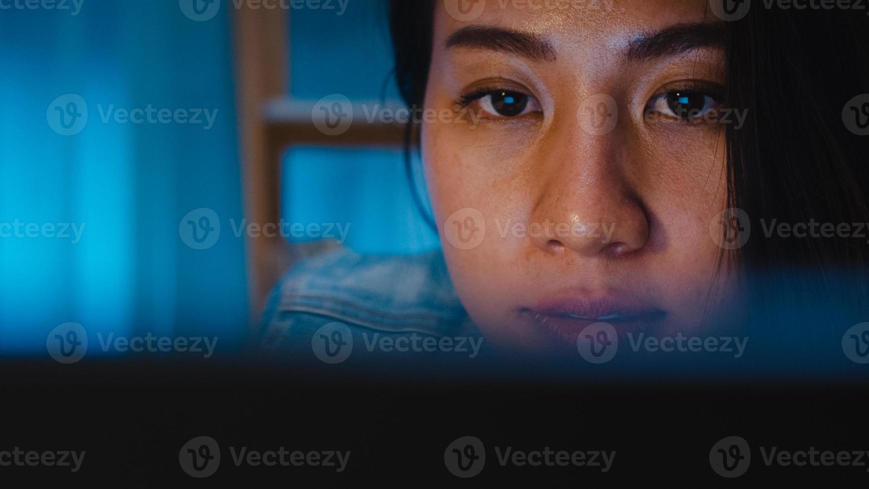 Jeune femme d'affaires chinoise millénaire travaillant tard dans la nuit avec un problème de recherche de projet sur un ordinateur portable dans le salon d'une maison moderne. concept de syndrome d'épuisement professionnel des personnes d'asie. photo