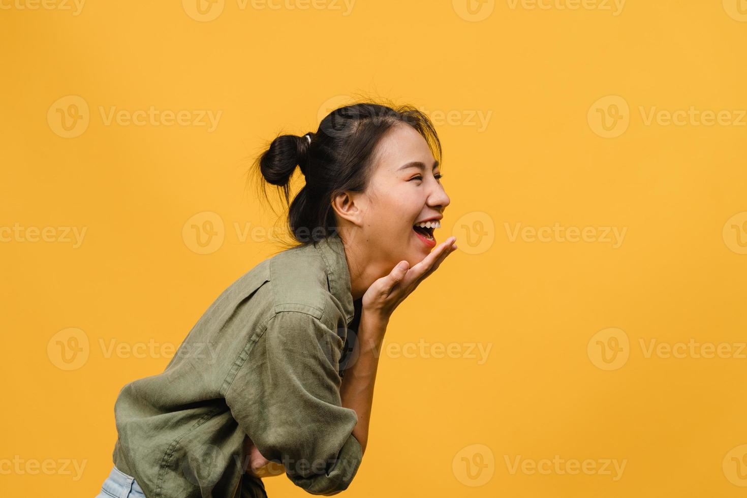 portrait d'une jeune femme asiatique avec une expression positive, un large sourire, vêtue de vêtements décontractés sur fond jaune. heureuse adorable femme heureuse se réjouit du succès. concept d'expression faciale. photo