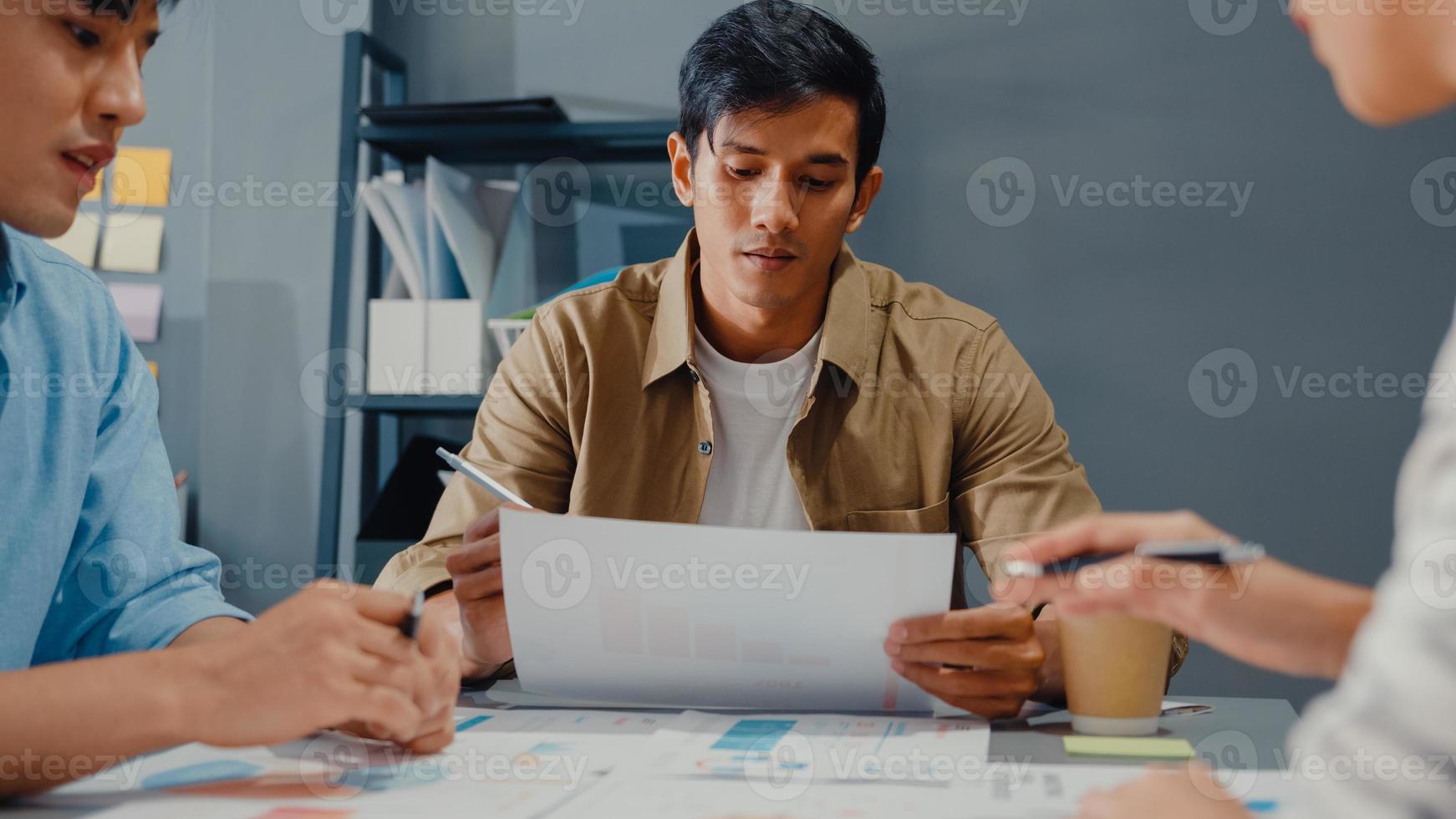 heureux jeunes hommes d'affaires et femmes d'affaires asiatiques se réunissant pour réfléchir à de nouvelles idées sur le projet à son partenaire travaillant ensemble pour planifier une stratégie de réussite profitez du travail d'équipe dans un petit bureau à domicile moderne. photo