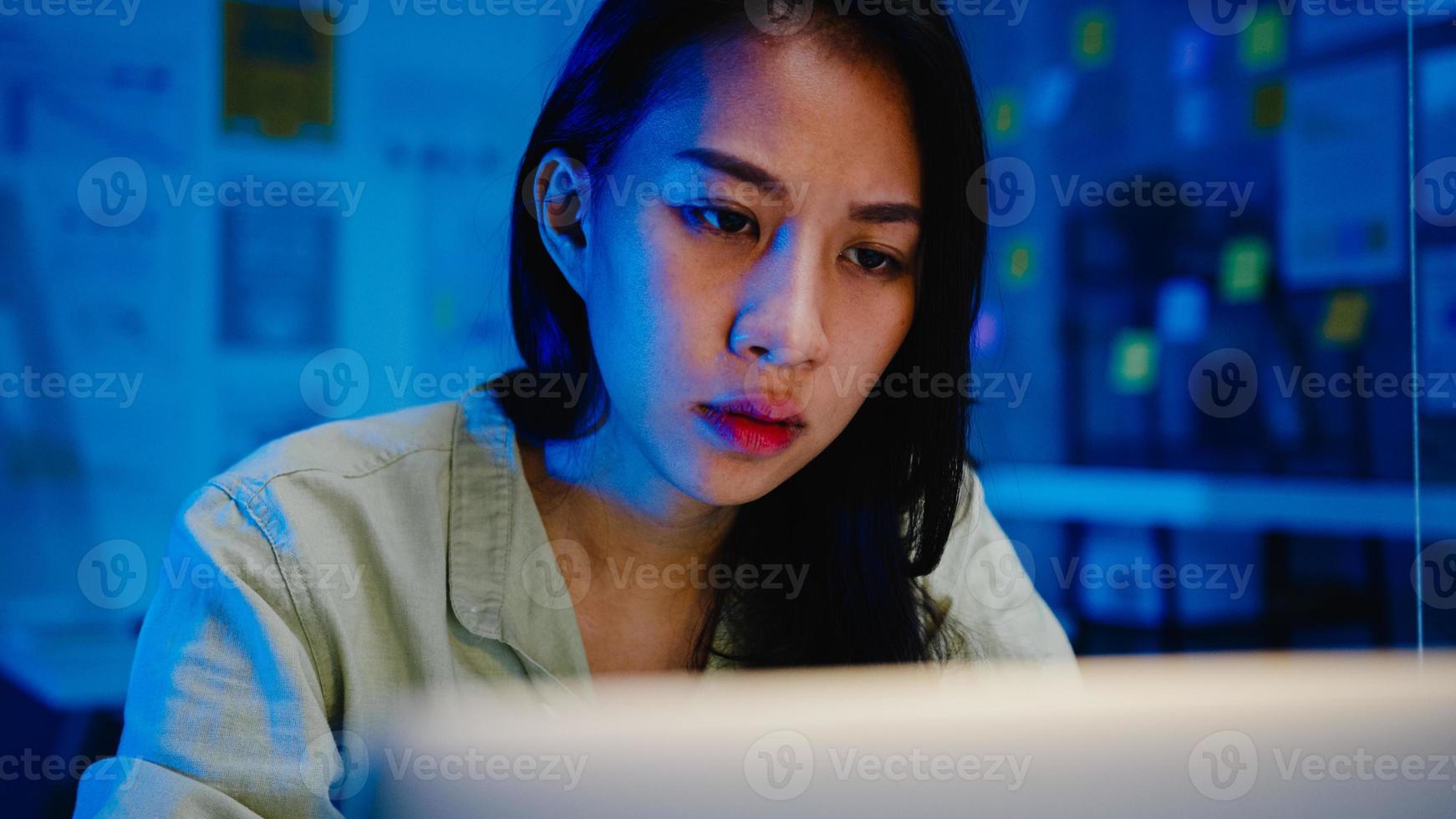 des femmes asiatiques indépendantes utilisant un ordinateur portable travaillent dur dans un nouveau bureau normal. travail à domicile surchargé la nuit, travail à distance, auto-isolement, distanciation sociale, quarantaine pour la prévention du virus corona. photo