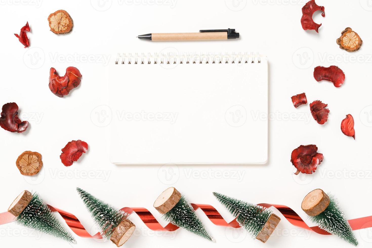 mise à plat créative minimale de la composition traditionnelle de noël d'hiver et de la saison des vacances du nouvel an. vue de dessus ouvrir le cahier noir de maquette pour le texte sur fond blanc. maquetter et copier la photographie spatiale. photo