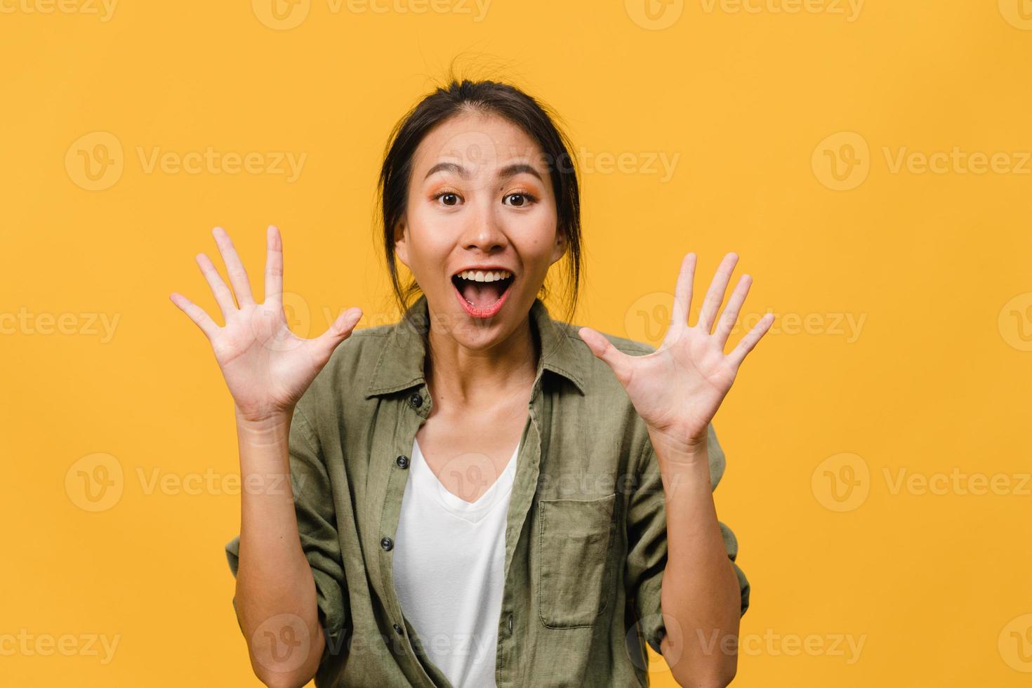 la jeune femme asiatique ressent le bonheur avec une expression positive, une joyeuse surprise funky, vêtue d'un tissu décontracté et regardant la caméra isolée sur fond jaune. heureuse adorable femme heureuse se réjouit du succès. photo