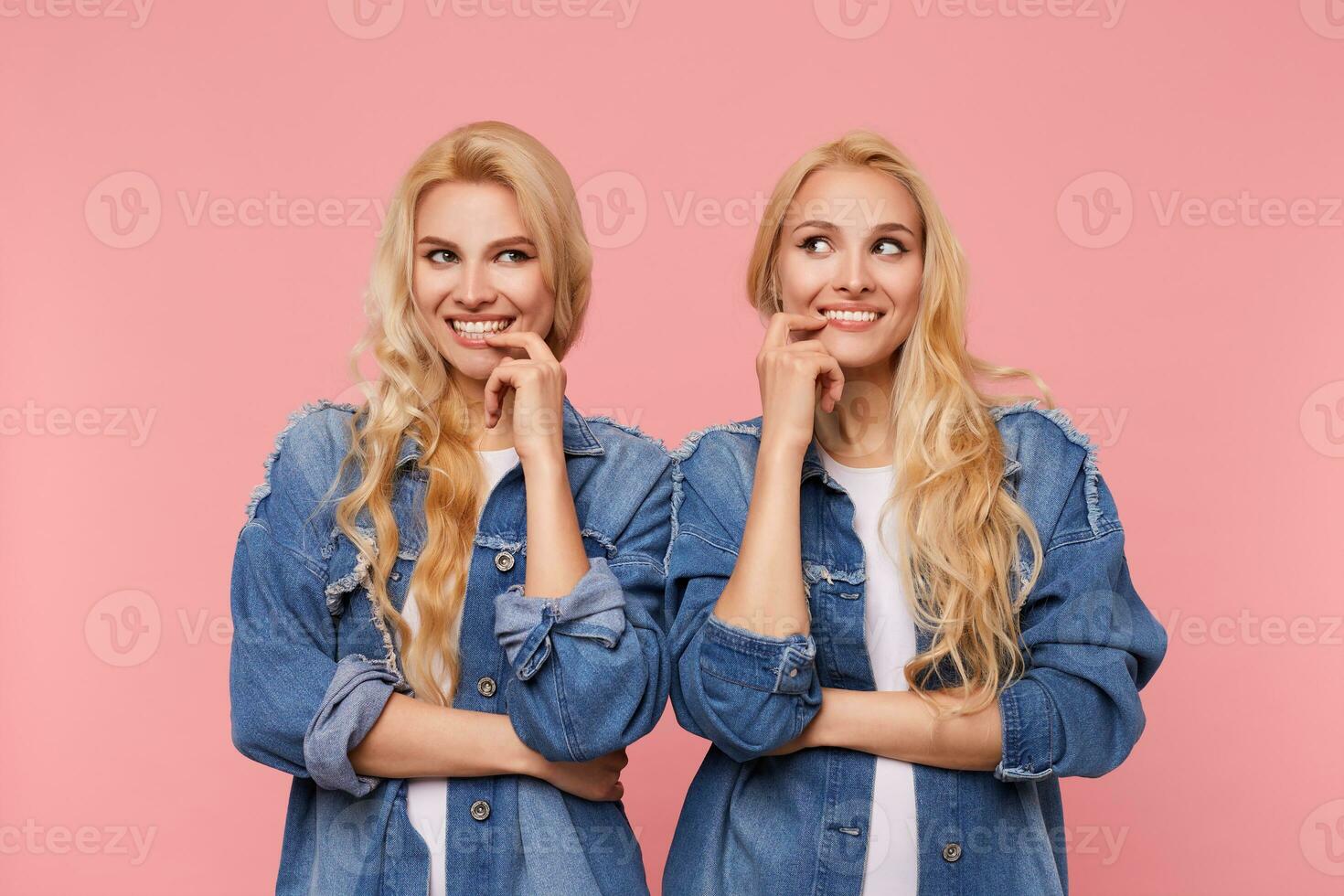 intérieur photo de Jeune longue aux cheveux blond femmes à la recherche volontier de côté avec large sourire et en gardant index sur leur lèvres, isolé plus de rose Contexte