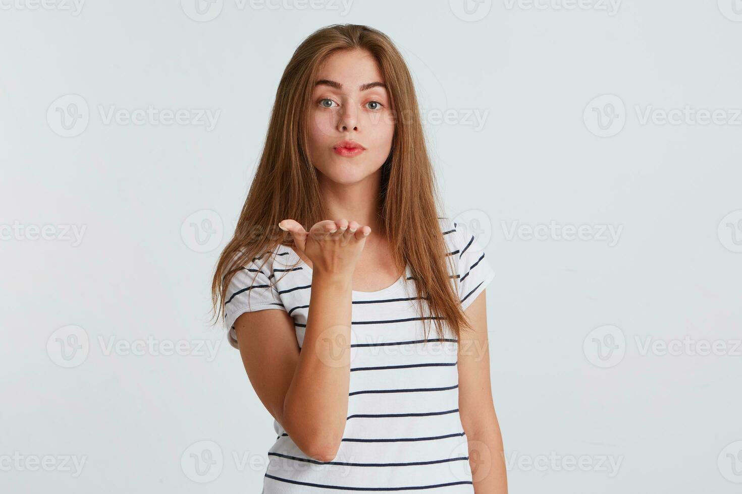 fermer de sur de soi attrayant Jeune femme avec longue cheveux porte rayé t chemise en portant copie espace sur paume dans de face de se isolé plus de blanc Contexte photo