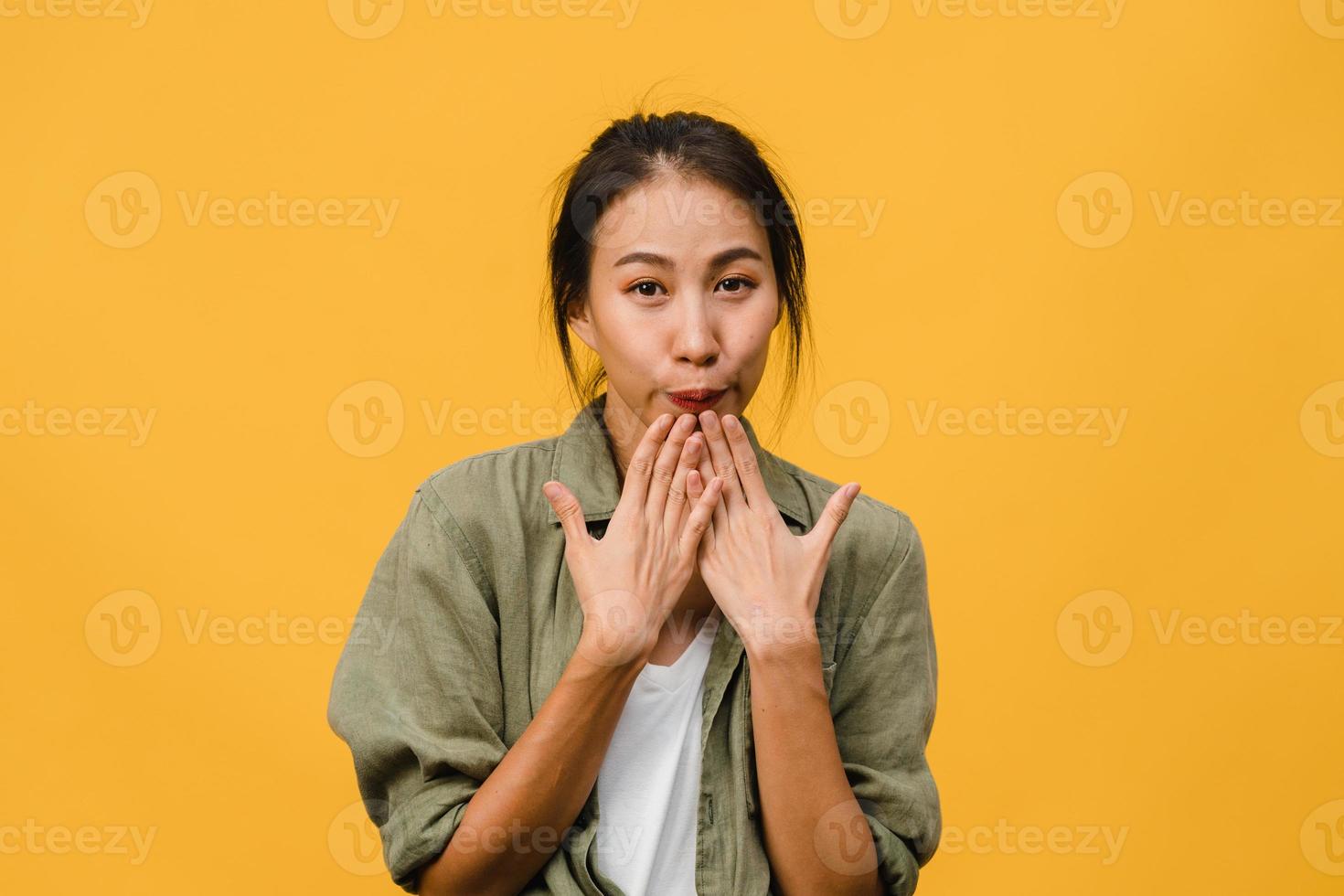 la jeune femme asiatique ressent le bonheur avec une expression positive, une joyeuse surprise funky, vêtue d'un tissu décontracté et regardant la caméra isolée sur fond jaune. heureuse adorable femme heureuse se réjouit du succès. photo