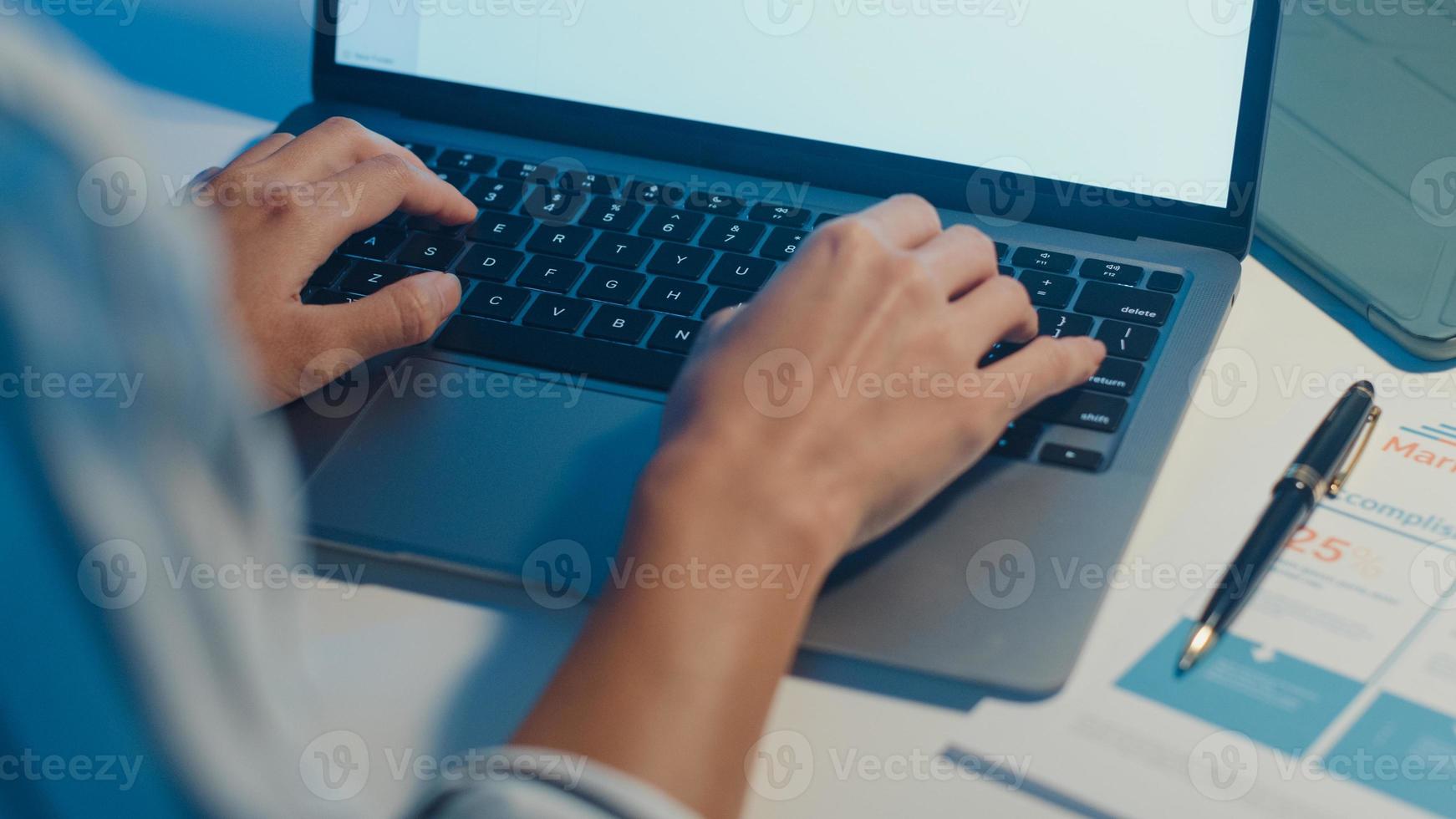 dame asiatique indépendante utilisant un ordinateur portable travaillant dur dans le salon de la maison. travail à domicile surchargé la nuit, travail à distance, auto-isolement, distanciation sociale, quarantaine pour la prévention du virus corona. photo