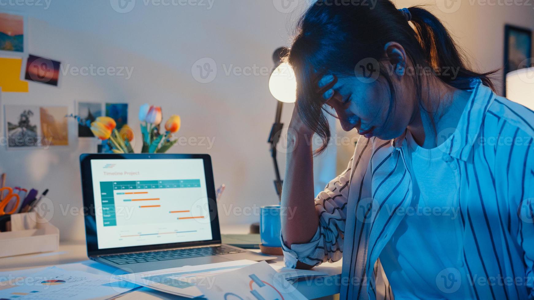 jeune femme d'affaires asiatique prépare la présentation avant l'entretien de la conférence au bureau à domicile. travail de la maison surchargée la nuit, à distance, distanciation sociale, quarantaine pour la prévention du virus corona. photo