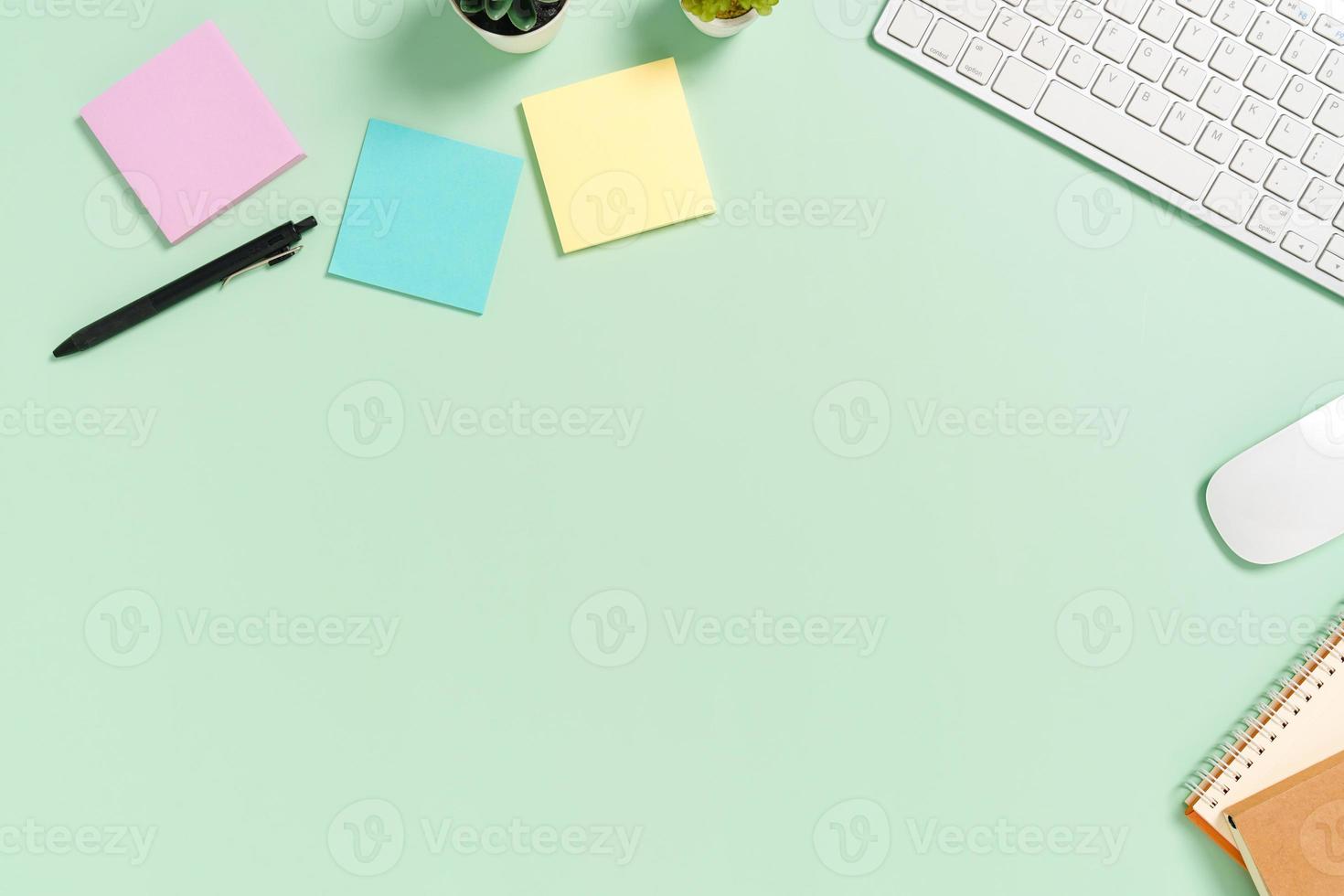 espace de travail minimal - photo créative à plat du bureau de l'espace de travail. bureau vue de dessus avec clavier, souris et livre sur fond de couleur vert pastel. vue de dessus avec espace de copie, photographie à plat.