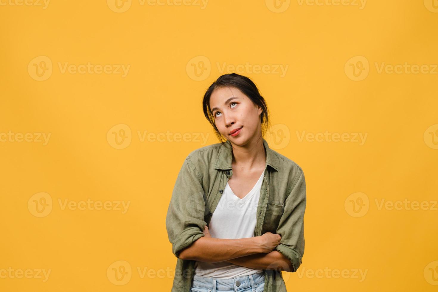 portrait d'une jeune femme asiatique avec une expression négative, des cris excités, des pleurs émotionnels en colère dans des vêtements décontractés isolés sur fond jaune avec un espace de copie vierge. concept d'expression faciale. photo