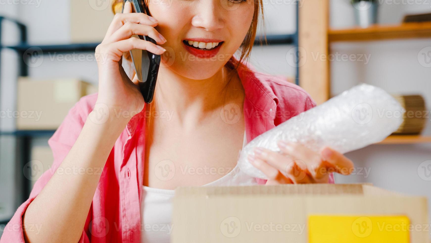 jeune femme d'affaires asiatique utilisant un appel téléphonique pour recevoir un bon de commande et vérifier le produit en stock, travailler au bureau à domicile. propriétaire de petite entreprise, livraison sur le marché en ligne, concept de style de vie indépendant. photo