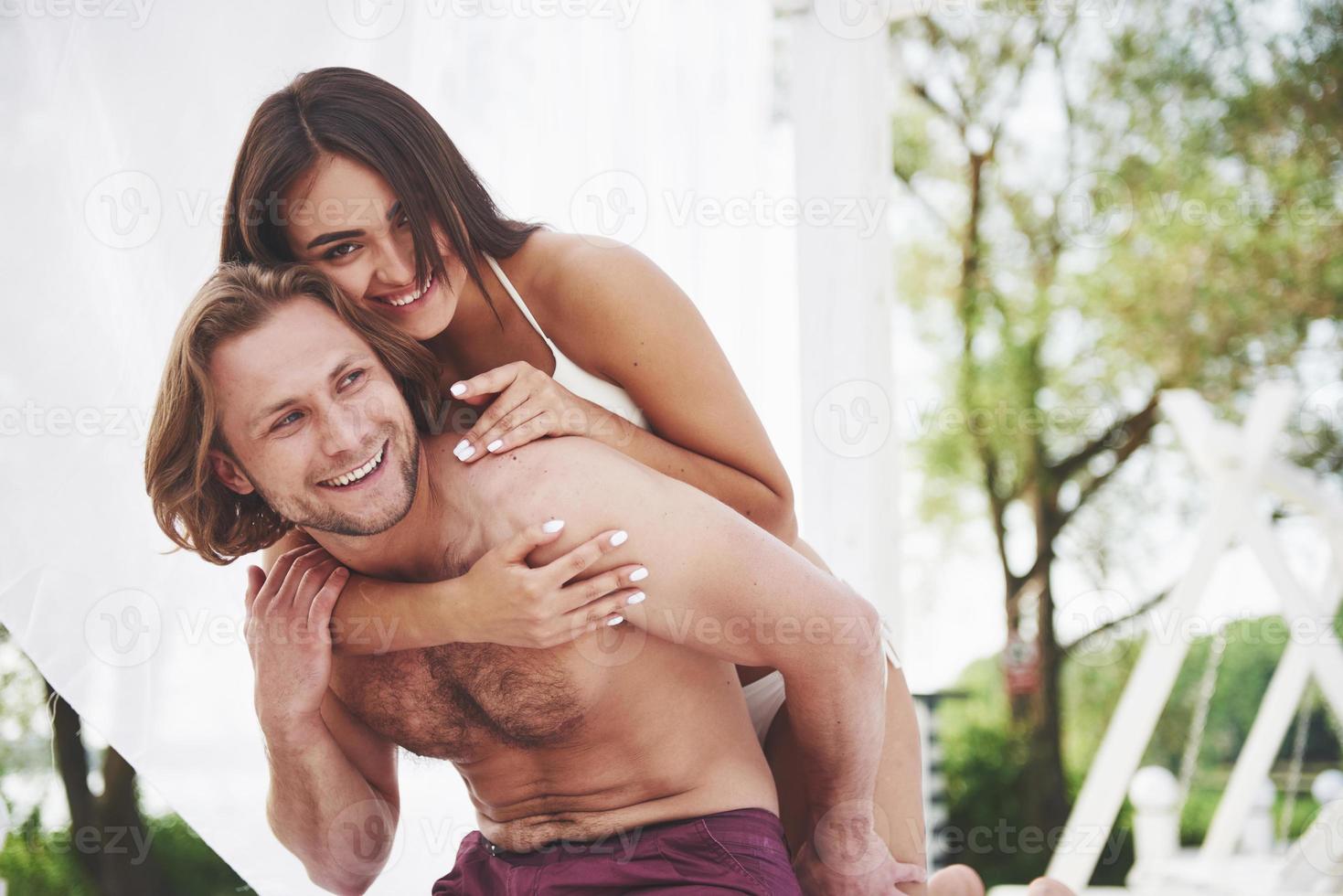 un beau couple se reposant sur la plage de sable, portant des vêtements de bain. atmosphère romantique photo