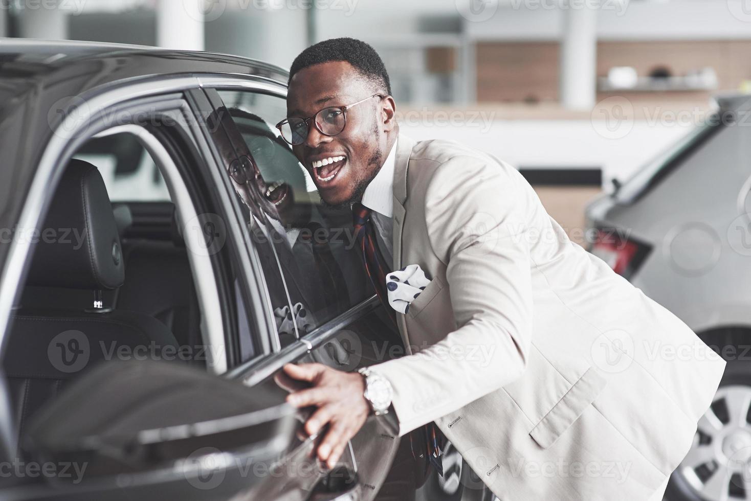 homme africain regardant une nouvelle voiture chez le concessionnaire automobile. photo
