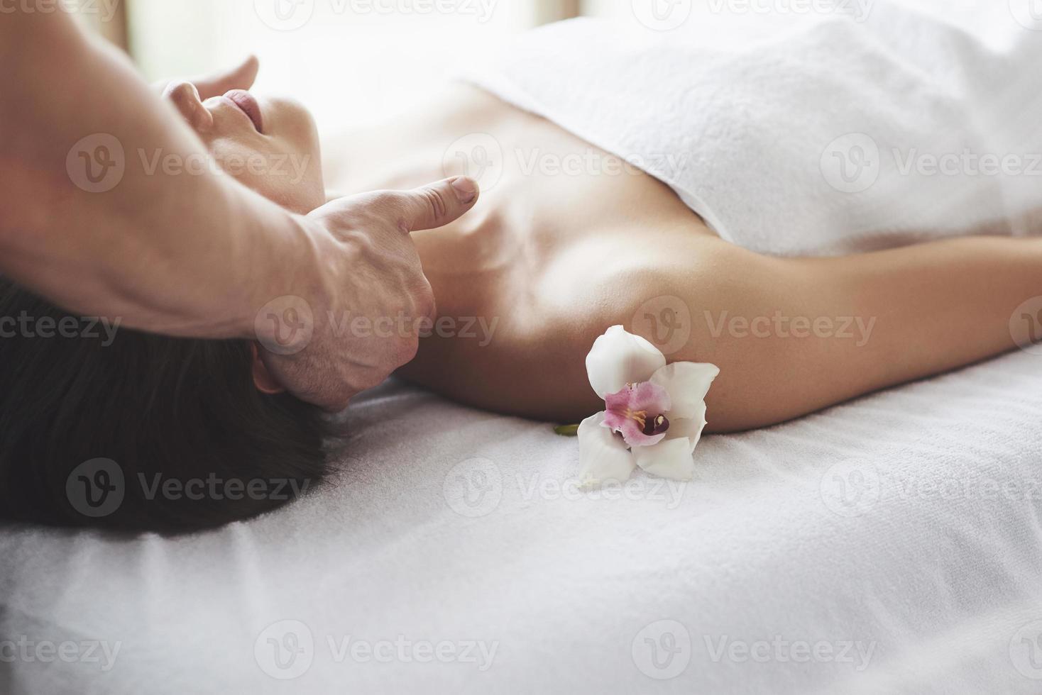 gros plan d'une jeune femme reçoit un massage au salon de beauté. procédures pour la peau et le corps. photo