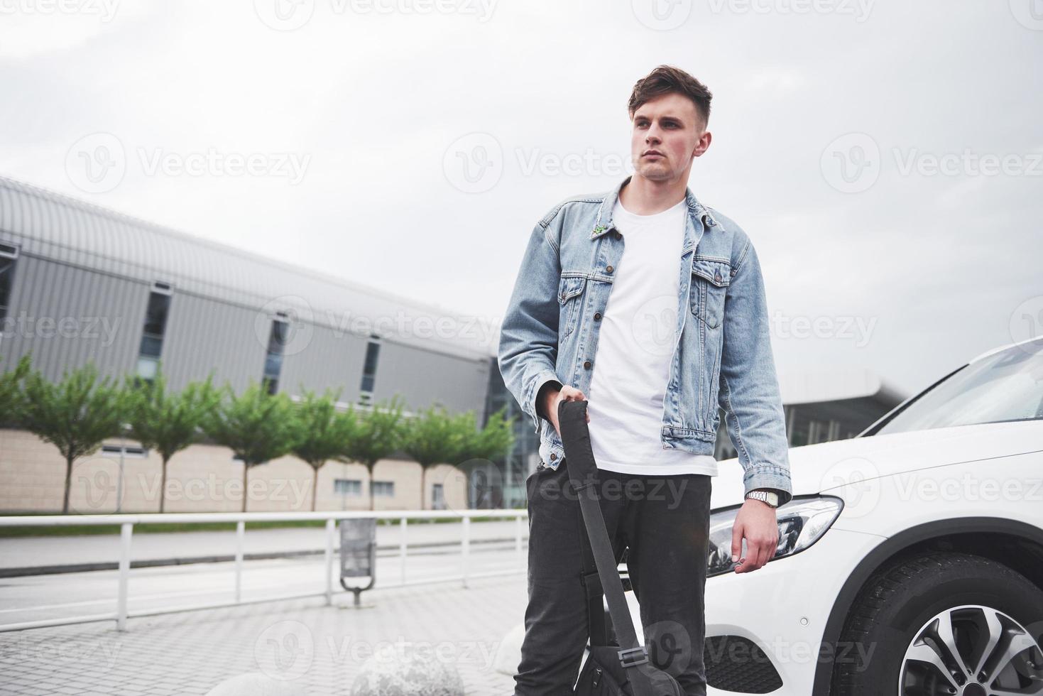 un beau jeune homme à l'aéroport attend le vol. photo