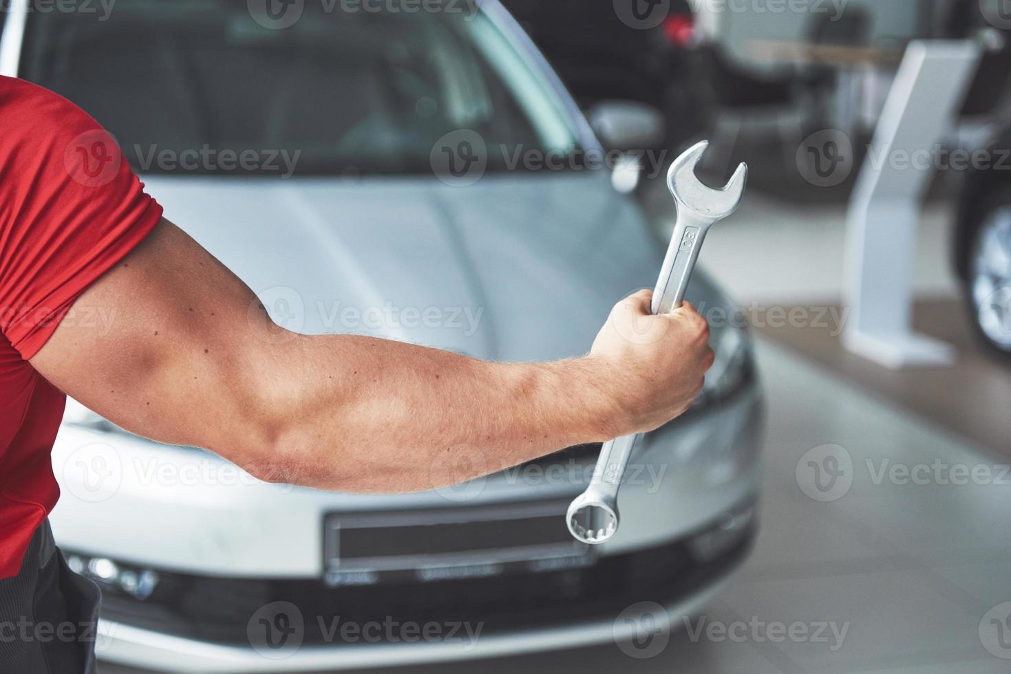 mains de mécanicien automobile avec clé dans le garage photo