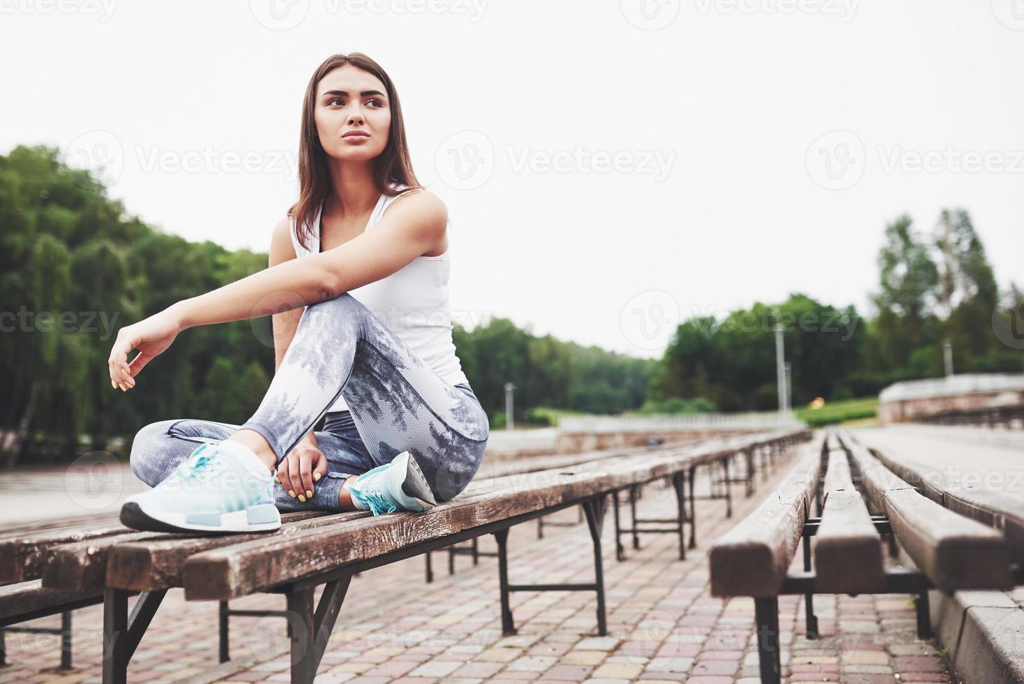 une belle brune athlète effectue des exercices en plein air photo