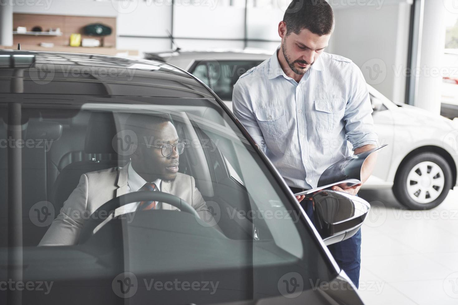 jeune homme d'affaires noir teste une nouvelle voiture. riche afro-américain photo