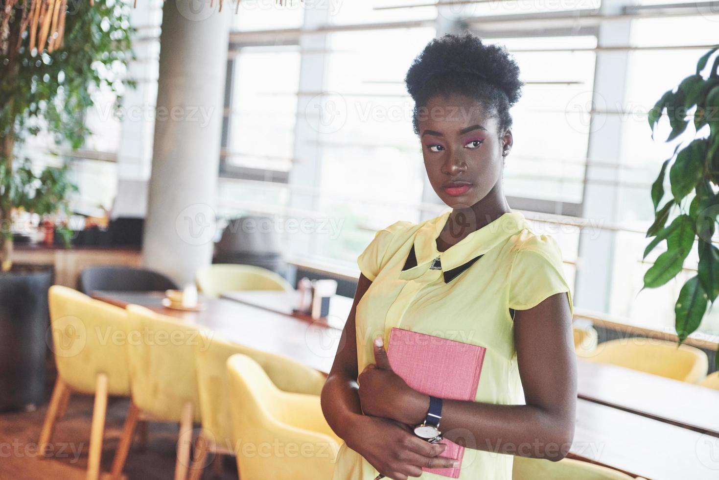 femme d'affaires afro-américaine se tient avec un dossier dans ses mains photo