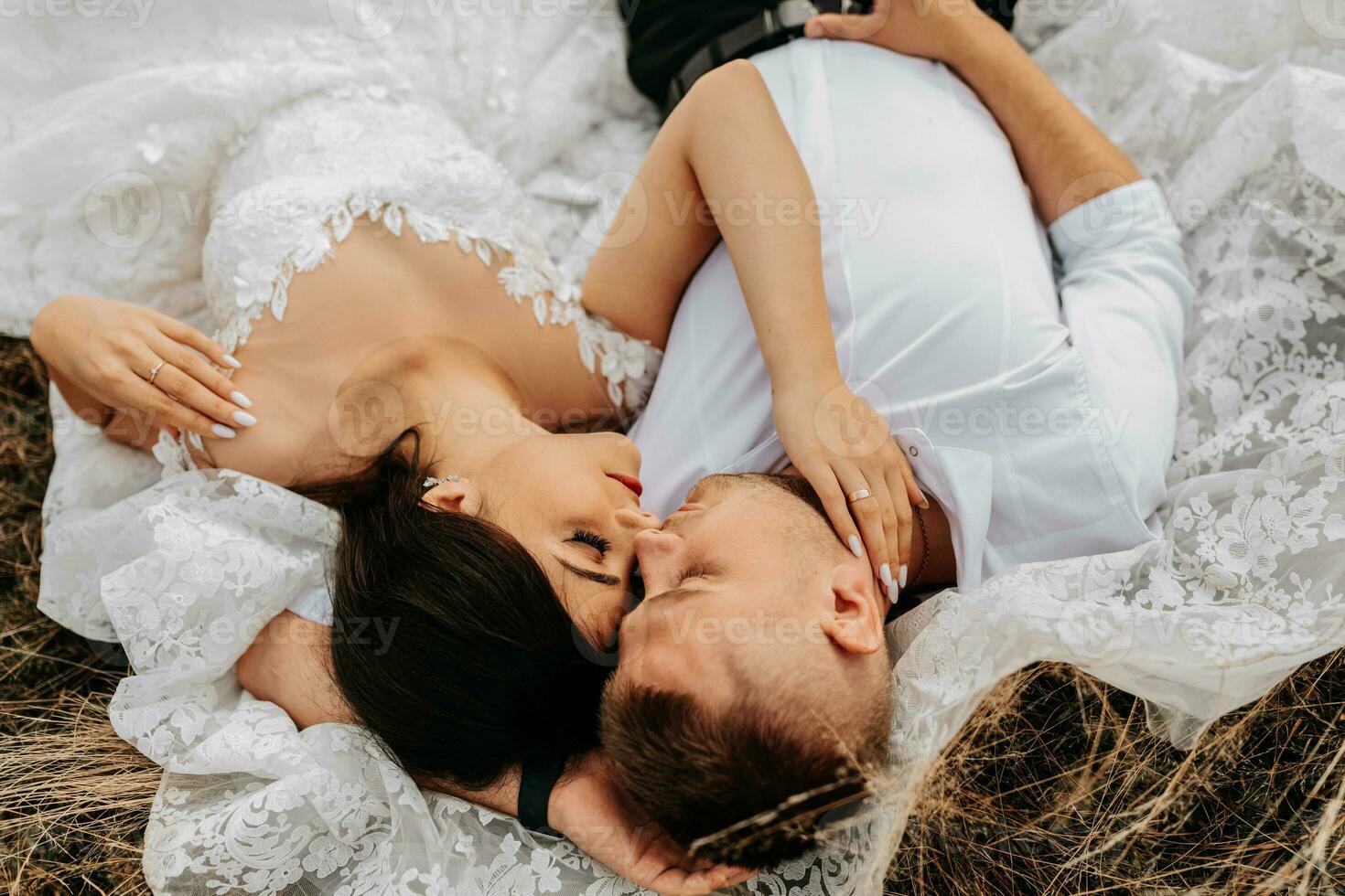 magnifique Jeune couple la mariée et jeune marié mensonge dans le herbe et étreinte. haute qualité photo