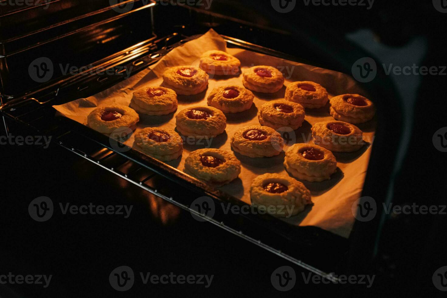 image de fait maison fraîchement cuit petits gâteaux dans une fermé électrique four. mode de vie, cuisson et dépenses temps à Accueil concept. photo