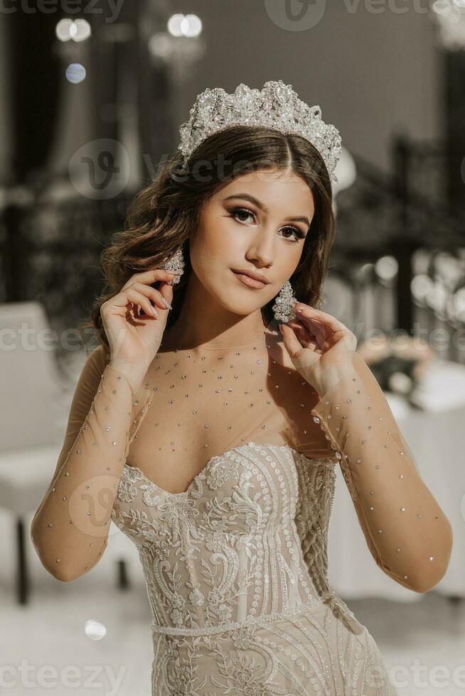 glamour studio photo de une fille avec longue marron cheveux dans une mariage robe. luxueux intérieur. verticale photo.