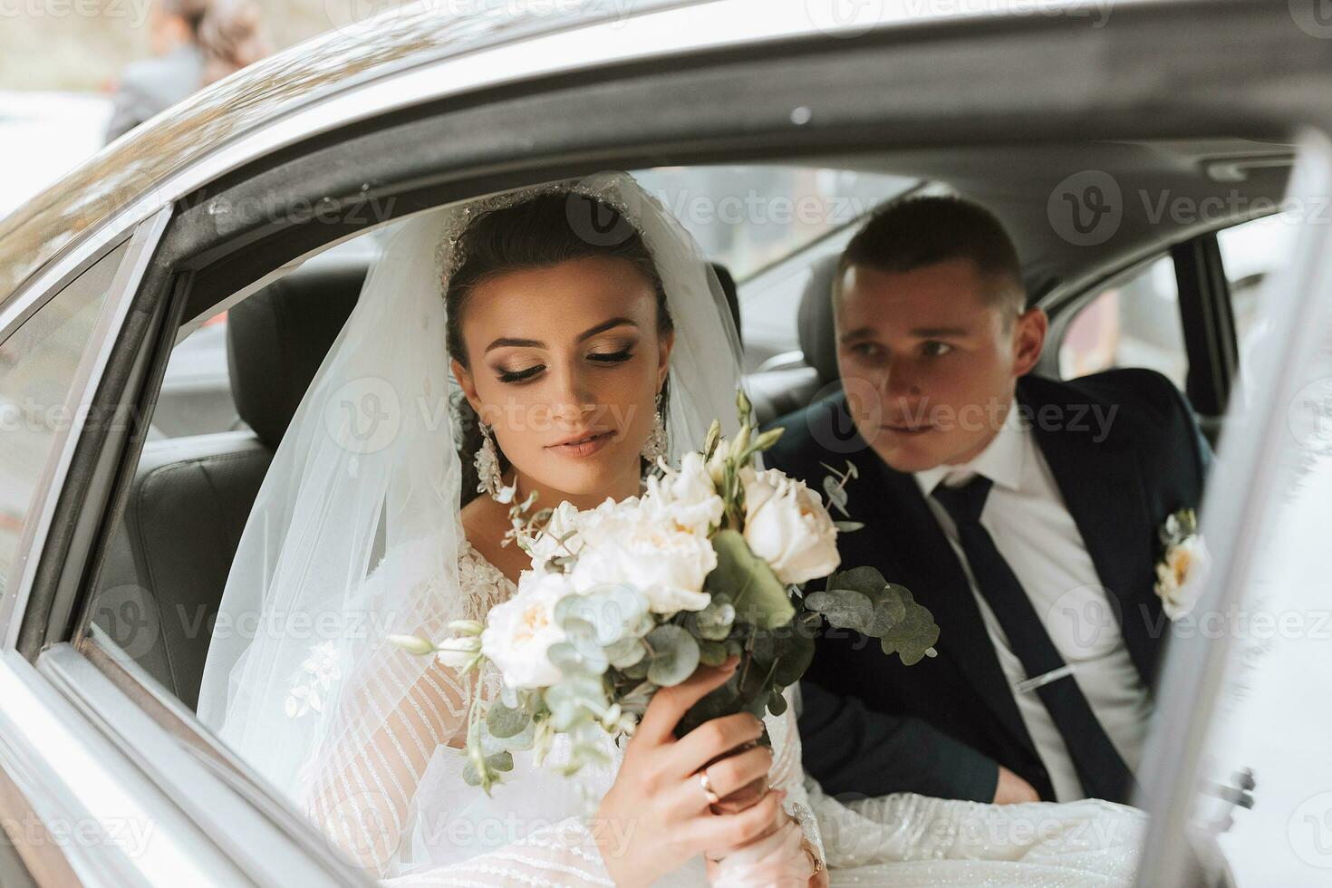 une moderne la mariée et jeune marié dans une dentelle robe dans une voiture la fenêtre. magnifique et souriant jeunes mariés. content vacances. photo