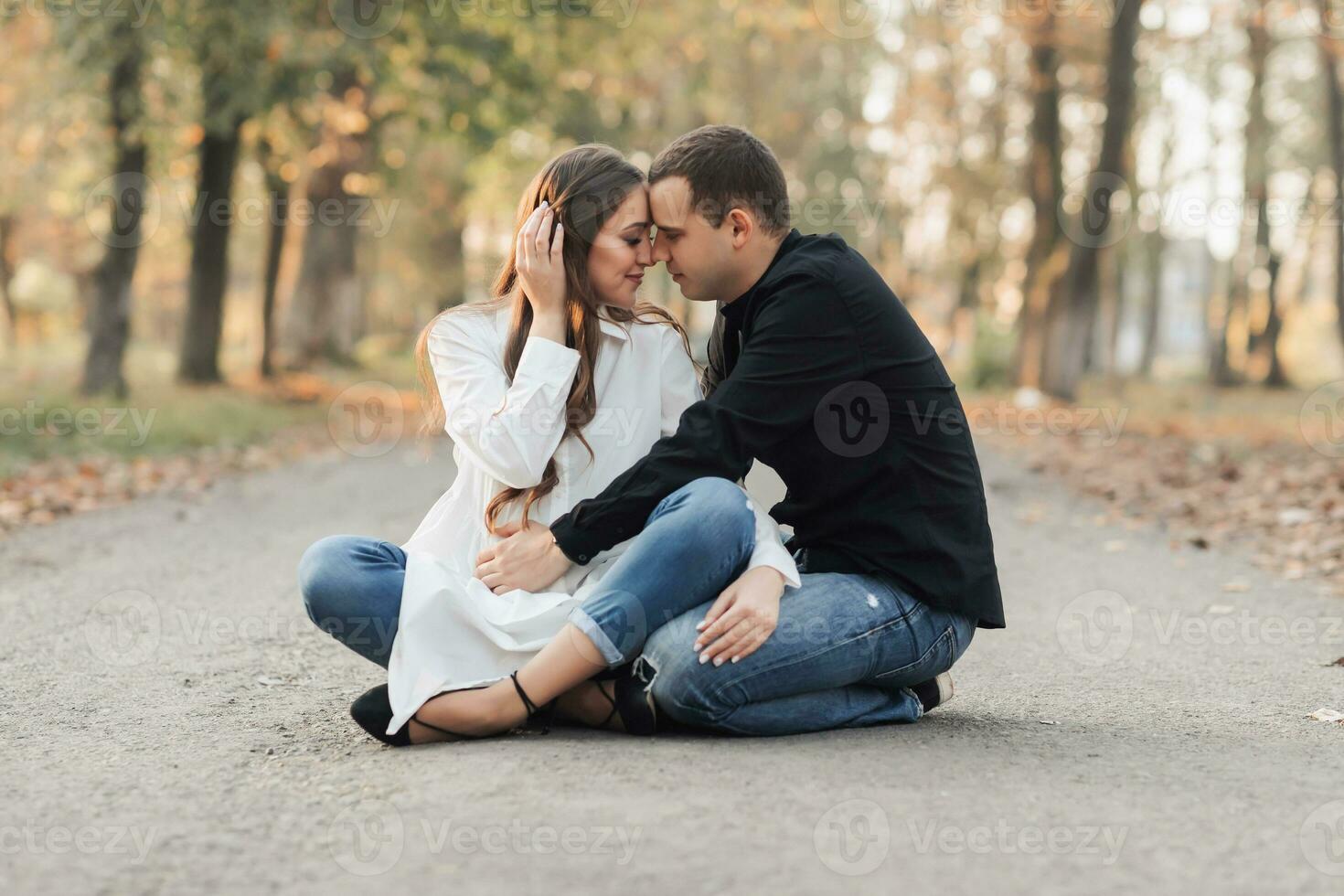 une homme près le sien Enceinte épouse, repos dans un l'automne parc. soutien de le mari pendant grossesse. le sujet de mental santé pendant grossesse photo