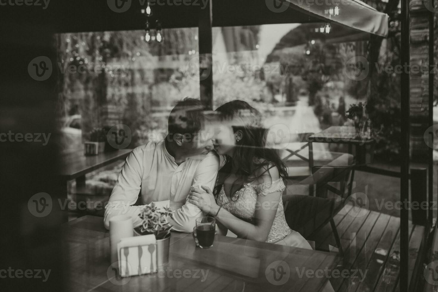 côté vue portrait de une aimant européen couple en riant tandis que profiter une Date dans une café. noir et blanc photo